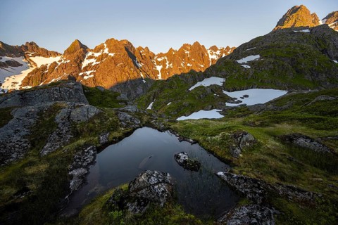 Rocky mountain peaks with reflection, small pond in moor landscape at Trollfjord Hytta, mountain