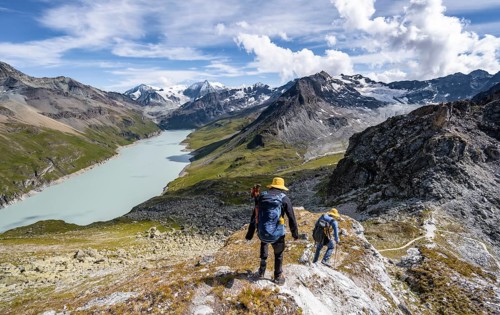 Two mountaineers on the summit of Mont de la Blana, view of a blue mountain lake, Lac des Dix