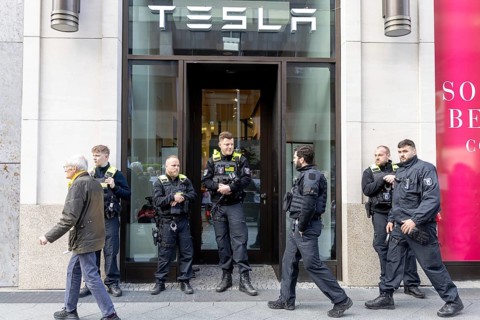 Berlin, Germany - 5 April 2025: Police guard the entrance to a Tesla shop as people demonstrate