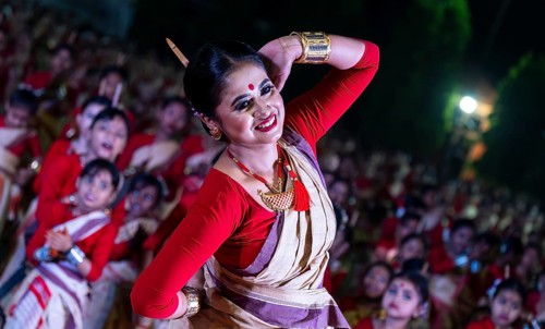 An instructor dance as participants follows the dance step in a Bihu dance workshop ahead of