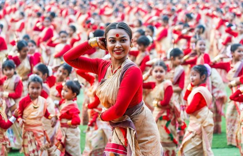 An instructor dance as participants follows the dance step in a Bihu dance workshop ahead of