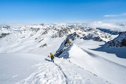 Mountaineer with ice axe and crampons, descent through steep snowfield on Piz Kesch or Piz d'Es-cha