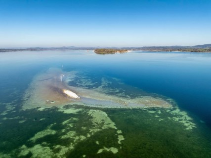 Aerial view of a shoal due to low water, drought, danger to shipping traffic, on the horizon the