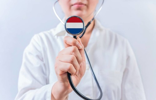 Female doctor holding stethoscope with Dutch flag. National health system of Netherlands