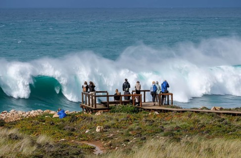 Carrapateira, Algarve, Portugal - Tourists on a viewing platform marvel at the roaring surf and