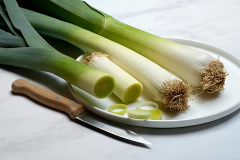 Leek, leek sticks on plate with knife, leek