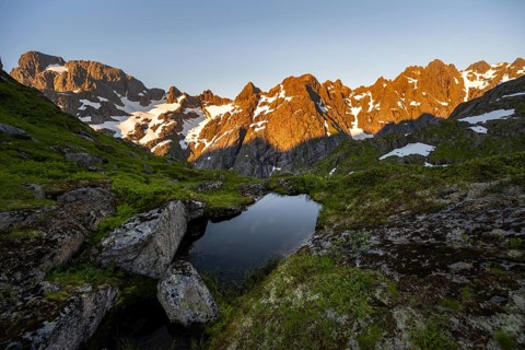 Rocky mountain peaks with reflection, small pond in moor landscape at Trollfjord Hytta, mountain