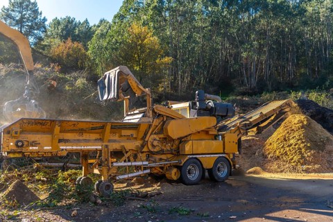 Full length photo of heavy machinery transporting waste outside a recycling plant