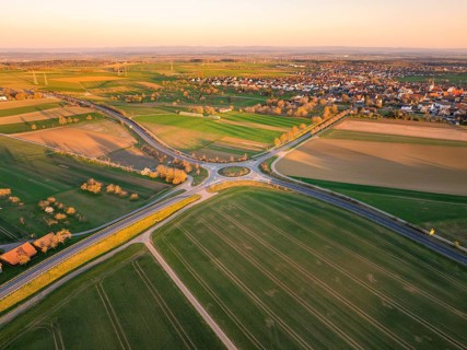 Shaded fields and a roundabout near a village at sunset, Nagold, Black Forest, Germany, Europe