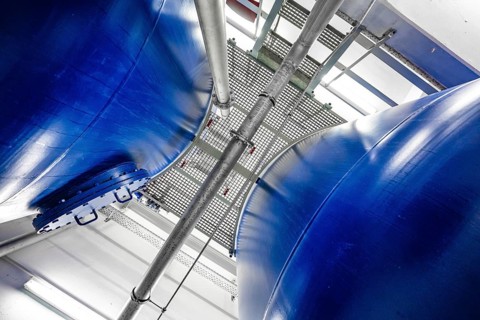 View between two large blue metal tanks with a grid attached to the top, ENCW Netze Calw