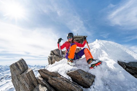Happy mountaineer with ice axes and crampons on the summit of Piz Grialetsch in winter, Graubünden