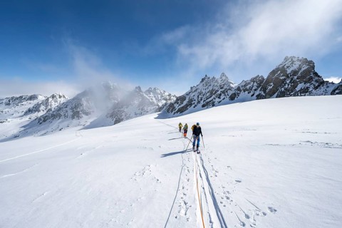 Ski tourer with rope, rope team on the Vadret da Porchabella glacier on the ascent to the summit of