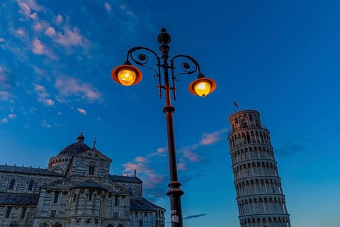The Cathedral of Santa Maria Assunta and the Leaning Tower under an illuminated street lamp in the