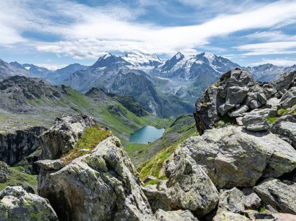 Mountain stream and mountain lake Lac de Louvie with glaciated summit of the Grand Combin, Val de