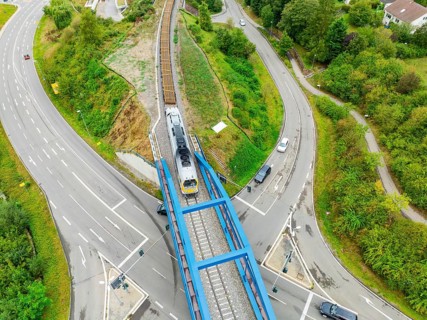 Railway train crosses a bridge with roads and vehicles, track construction, rail delivery for