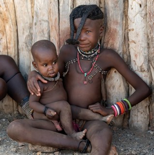 Himba girl with forward braided plaits with baby, near Opuwo, Kaokoveld, Kunene, Namibia, Africa