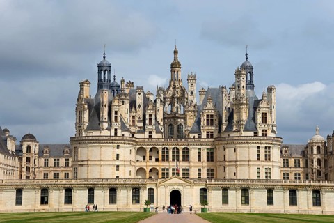 Close-up of a magnificent castle with detailed decorations and high towers under a slightly cloudy