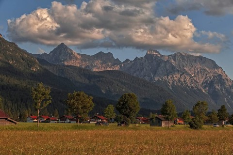 Mountains in the background of a small village with clouds in the sky in a natural landscape,