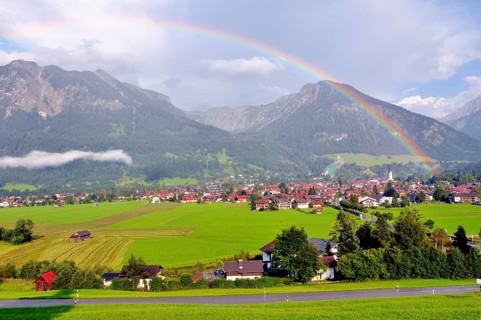 View over Oberstdorf with rainbow, behind it the Schattenberg with Schattenbergschanze, Oberallgäu,
