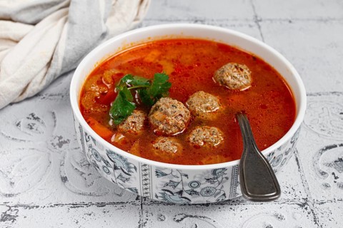 Romanian soup with meatballs, vegetable soup with meatballs, tiled table, homemade, no people