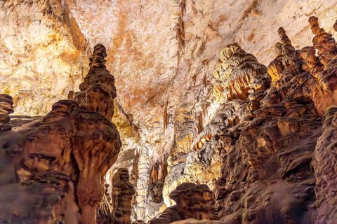 Breathtaking view of illuminated stalagmites and stalactites forming stunning geological structures