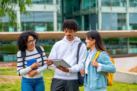 Multi-ethnic students reading notes before an exam in the university standing outside the campus