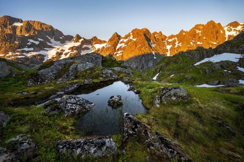 Rocky mountain peaks with reflection, small pond in moor landscape at Trollfjord Hytta, mountain