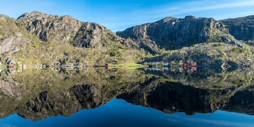Near Ana-Sira at the norwegian southern coast, lonely houses at the foot of a rock formation are
