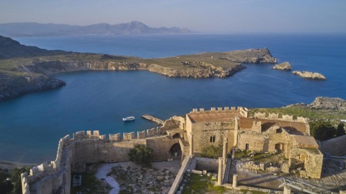 Drone shot, Acropolis of Lindos, Late afternoon light, Rock fortified historical site above a calm