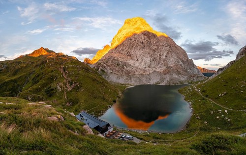 Alpenglow at Seekopf or Monte Capolago, reflection in Lake Wolayersee with Alpine Club hut