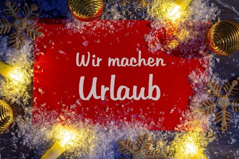 Sign with the inscription WIR MACHEN URLAUB with Christmas decorations