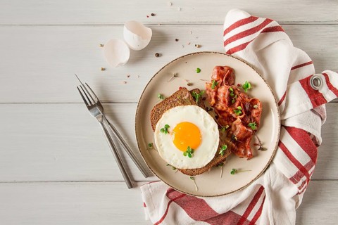 Breakfast, fried egg with bacon, micro-green, on a light background, no people, selective focus