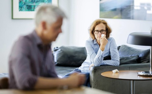 Symbolic photo on the subject of problems in a partnership. An older woman and an older man sitting