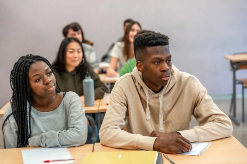 Multi ethnic university students listening attentively to a lecture in a classroom setting, focused