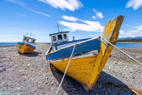 Colourful fishing boats lying ashore at low tide, Hualaihue, Hornopiren, Los Lagos region,