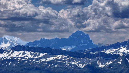 View of impressive mountain range with snow-covered peaks under dramatic clouds, Oberstaufen,