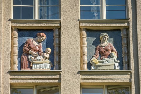 Mothers looking after their babies, relief on an old building, former woman's and children's