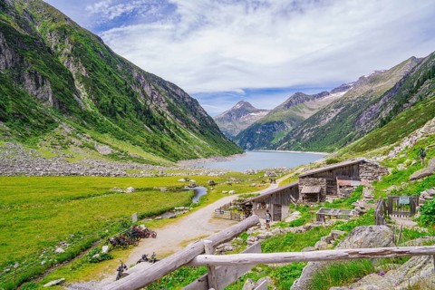 View of a mountain landscape with a lake, huts and a path through a green meadow, Klein Tibet,