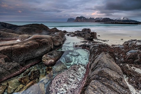 Rocks and beach in front of Bergen, sea, surf, spray, clouds, winter, Flakstadoya, Lofoten, Norway,