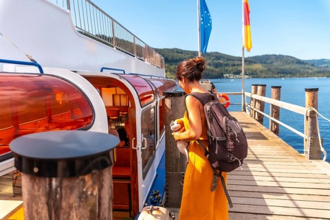 A female tourist boarding a boat on Lake Titisee in the Black Forest of Germany
