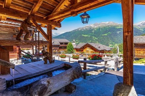 Wooden sculptures with sawmill motifs on the village square, historic village centre, Grimentz, Val