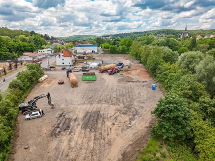 Landscape view of a large construction site in the countryside, surrounded by houses and a cloudy