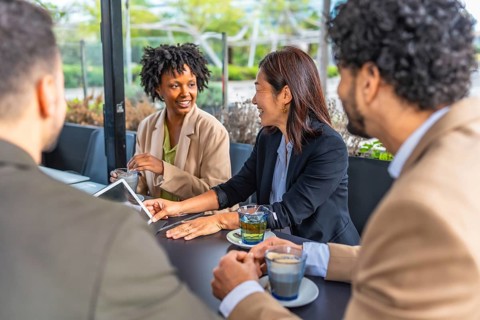 Business people using digital tablet during a meeting in a modern cafeteria