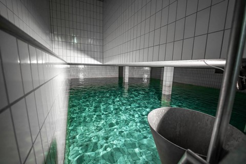 Large water basin with tiled walls and reflecting water, ENCW Netze Calw waterworks, Calw, Black