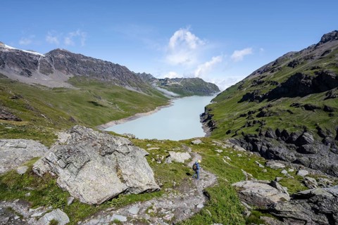 Mountaineer on hiking trail in front of Lac des Dix reservoir, Valais Alps, Valais, Switzerland,