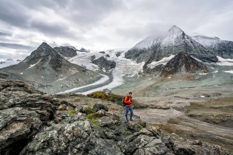 Mountaineer in front of impressive mountain landscape, mountain hut Cabane des Dix in front of