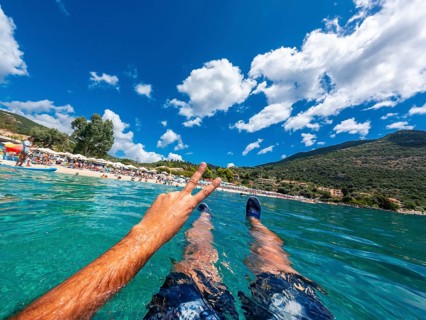 Resting in the sea on the beach in summer of Paralia Mikros Gialos in the south of the island of