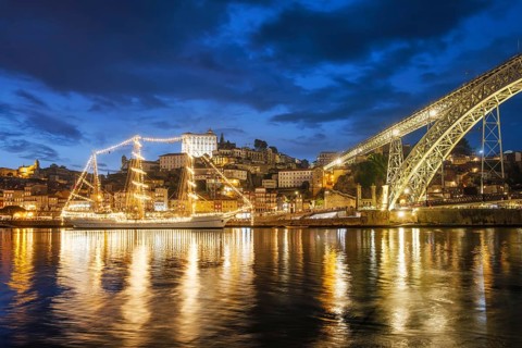 View of Porto city and Douro river with sailing ship from famous tourist viewpoint Marginal de Gaia