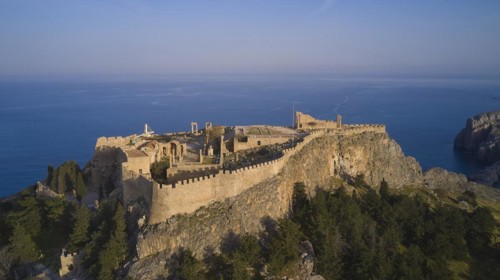 Drone shot, Acropolis of Lindos, Late afternoon light, Historic castle on a cliff above the sea in