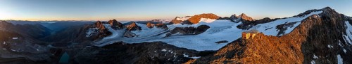 PanoraAtmospheric sunrise in picturesque mountain landscape, alpenglow, aerial view, mountain hut